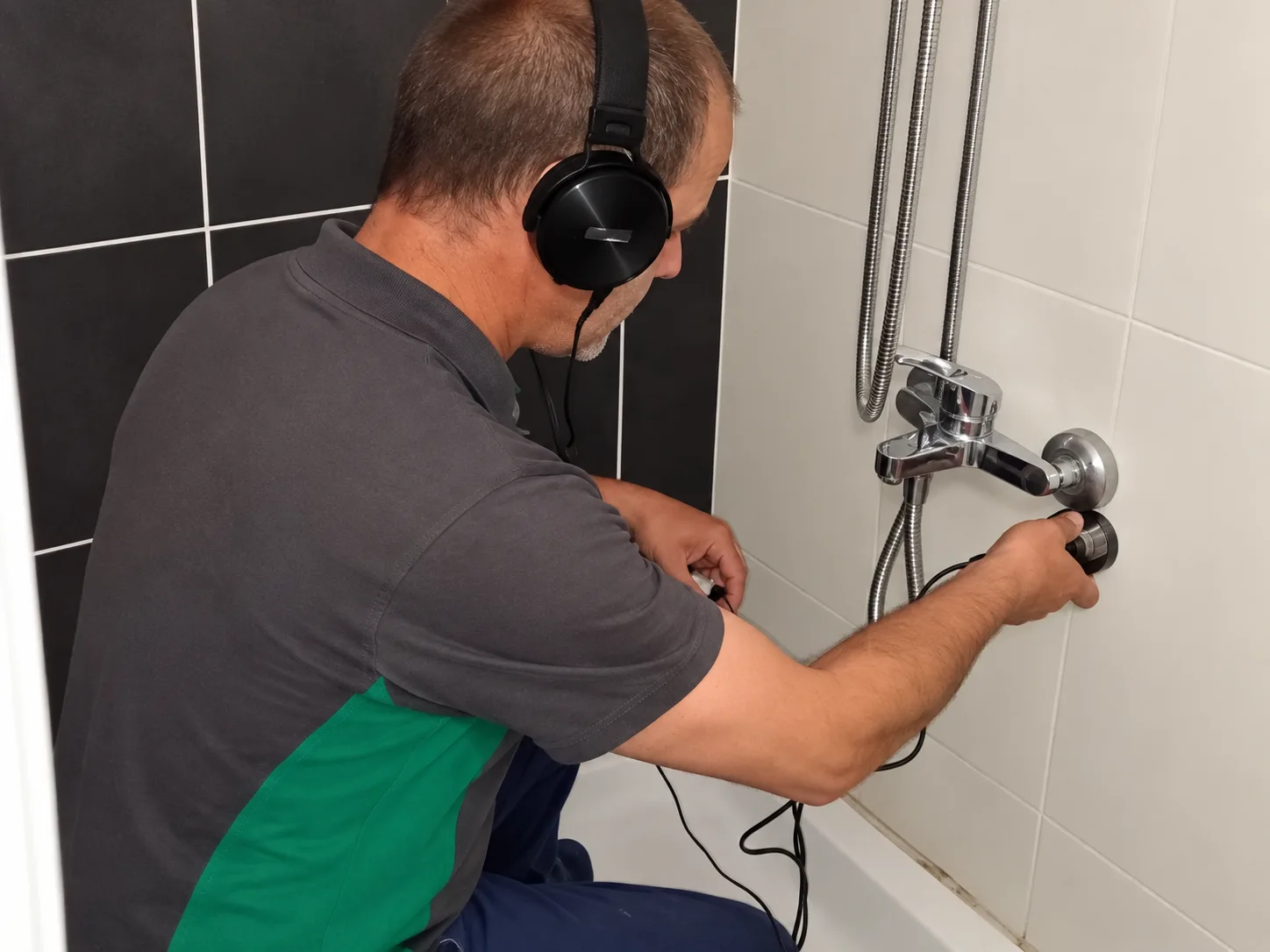 Banyo bağlantısında akustik dinleme cihazı kullanan teknisyen