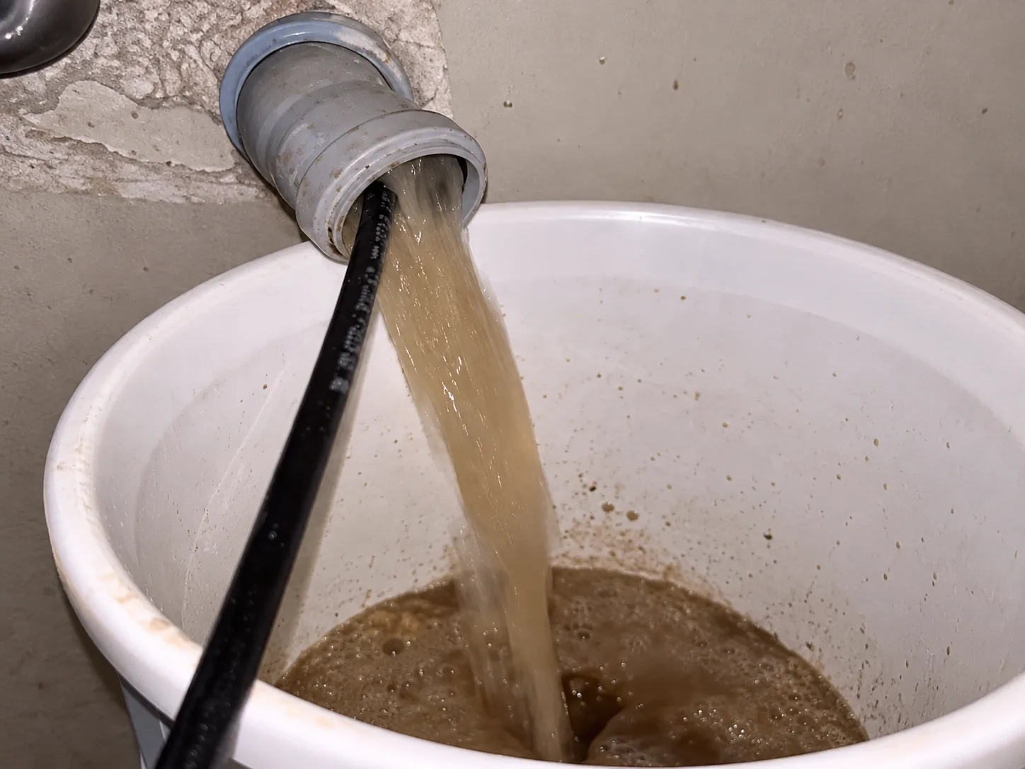 Gider hattından gelen suyun beyaz toplama kabına akması