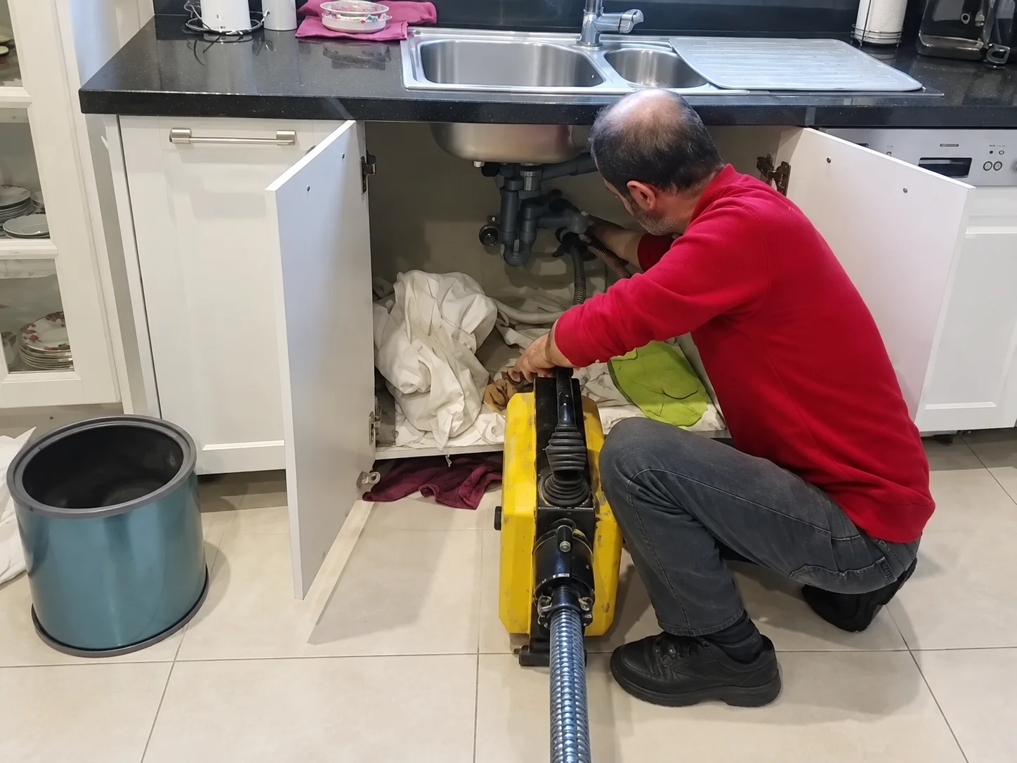 Mutfak dolabı önünde spiral cihazla çalışan teknisyen