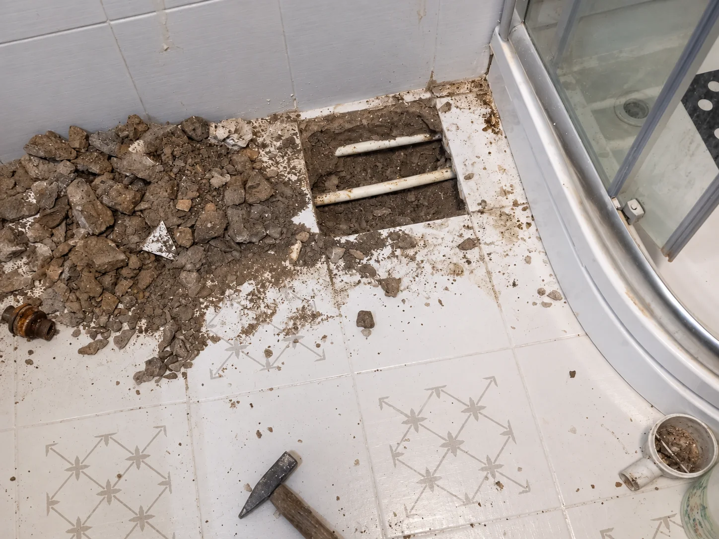 Duş kabini yanında açılan zeminde görünen iki tesisat borusu
